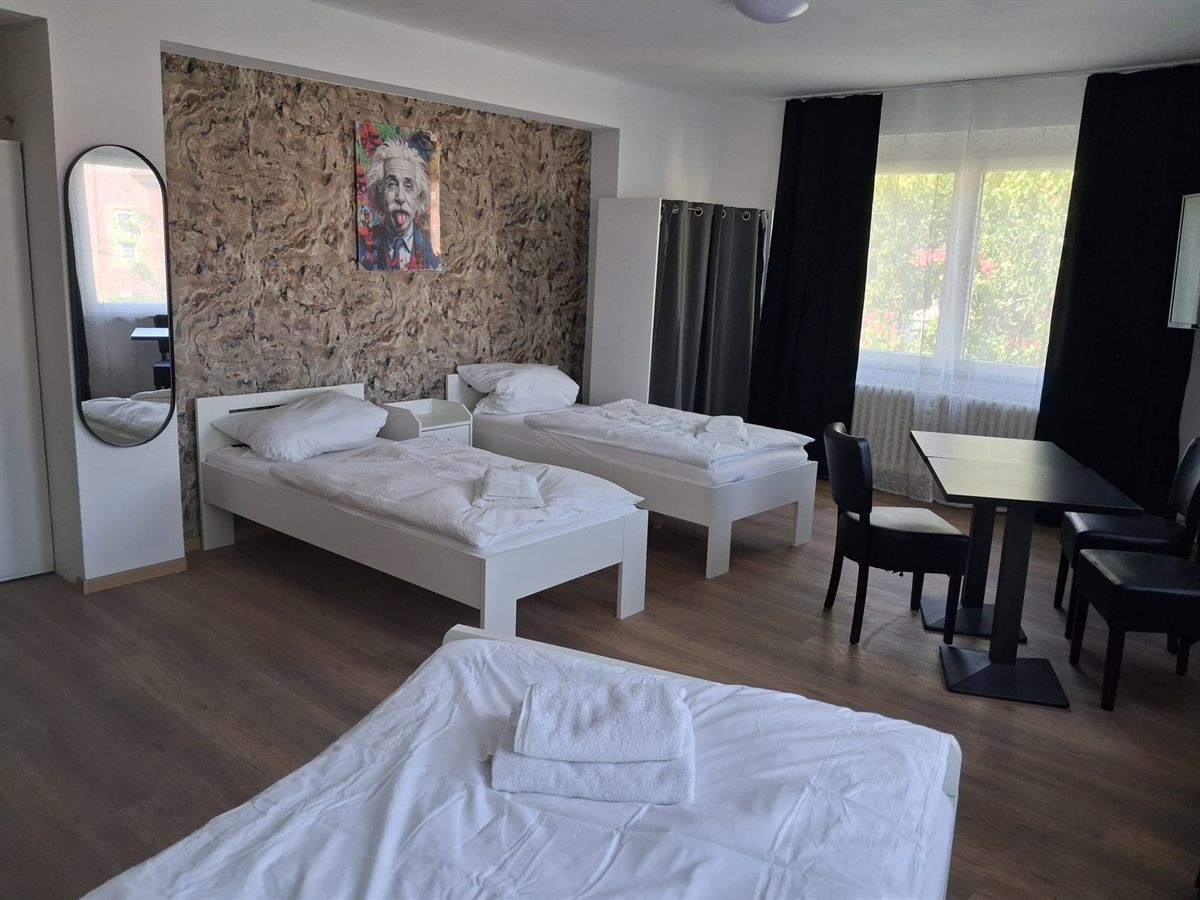 Dreibettzimmer für ein Aufbauteam, drei Betten und Tisch