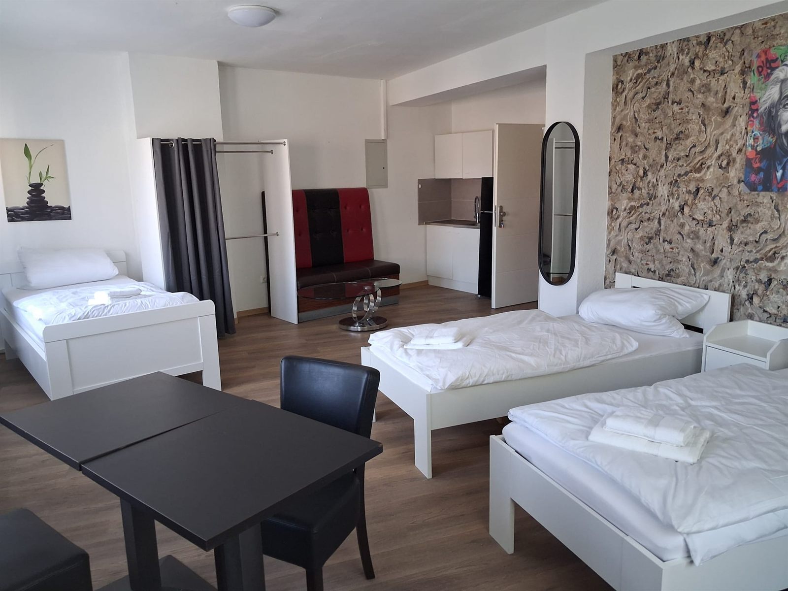 Möbliertes Zimmer für Messegäste in Duisburg mit Bett, Schrank und Fenster